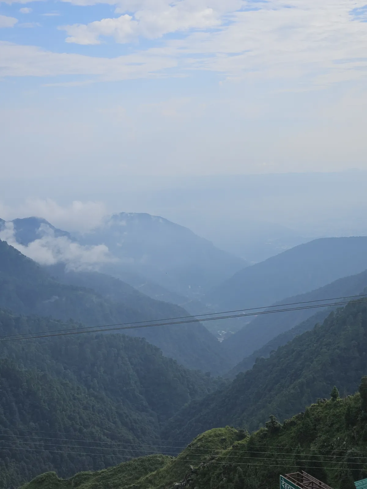 Misty Doon Valley and layered Himalayan ridges viewed from Highlanders Café & Stay, a quiet mountain view stay in Suwakholi near Mussoorie