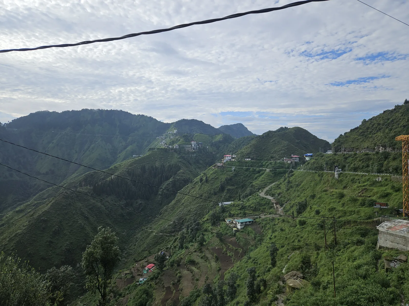 Green terraced hills and a winding mountain road on the Dhanaulti Road side near Suwakholi, Mussoorie, Uttarakhand