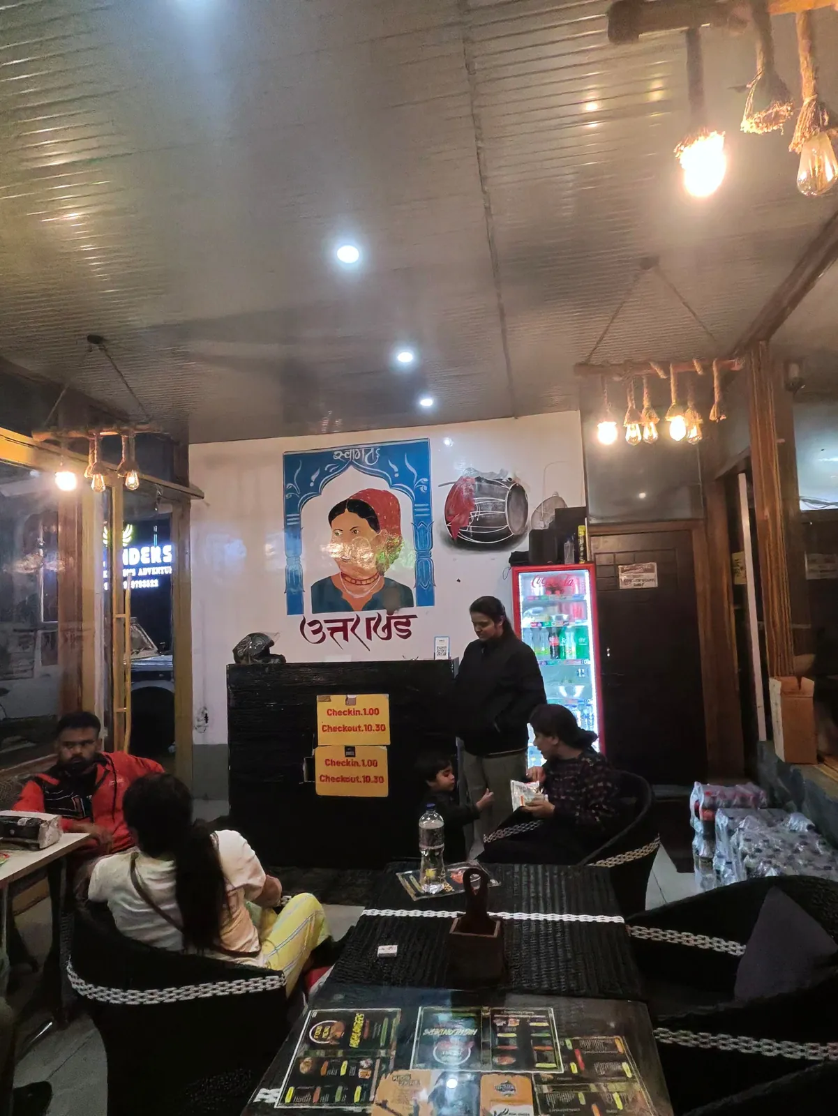 Highlanders Café interior with warm lights, cushioned seating and a counter in Suwakholi near Mussoorie, a mountain café open to guests and walk-ins